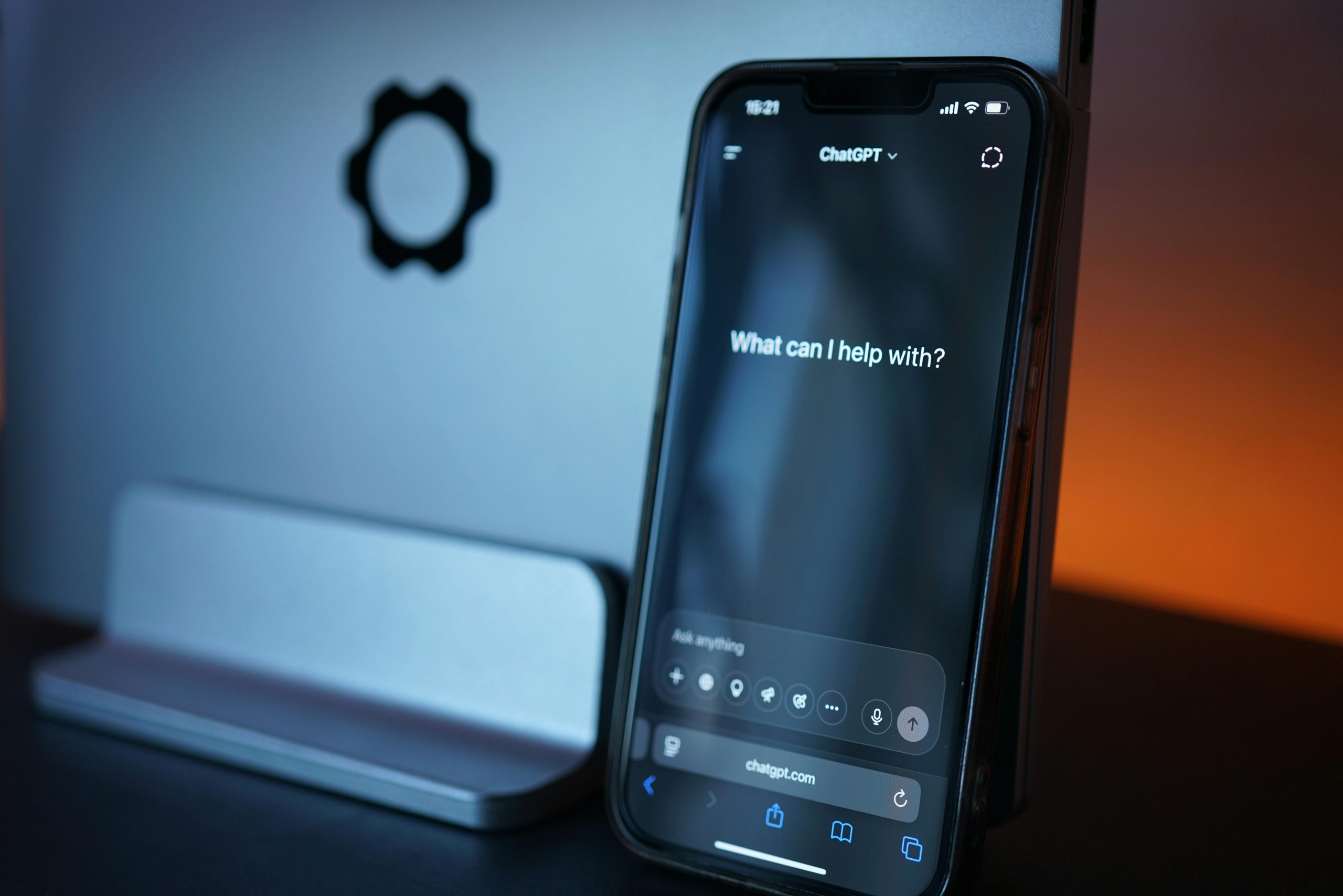 Phone with ChatGPT leaning against Laptop